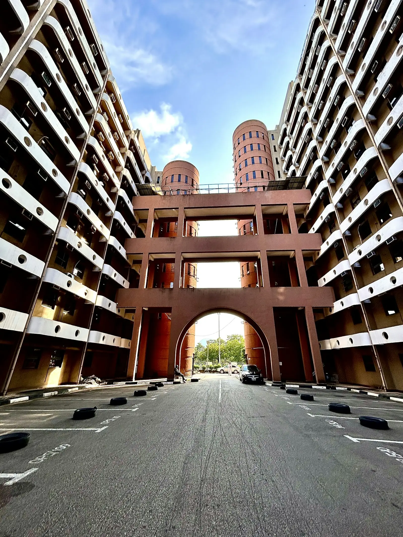 A brick arcade framed by apartment blocks