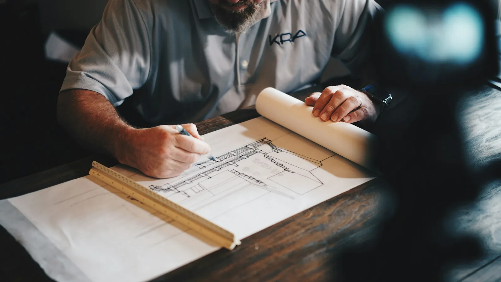 An architect drawing a plan by hand with a scale rule